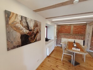 A dining area with a long wooden table, white chairs, and a modern ceiling design. - Alter Speicher (Schönberg)