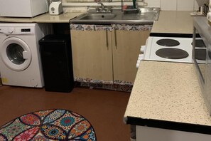A compact kitchen with a washing machine, a sink, and a stove. - Sleeps 2 With Free Parking and Wi-fi (Birmingham)