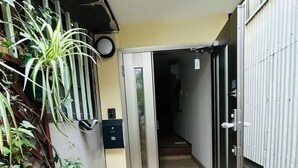 A doorway leading into a building with a tiled floor and a metal gate on the right. - Sky Building Umeda (Osaka)
