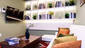 A modern living room with a flat-screen TV, a bookshelf, and a white sofa. - Sky Building Umeda (Osaka)