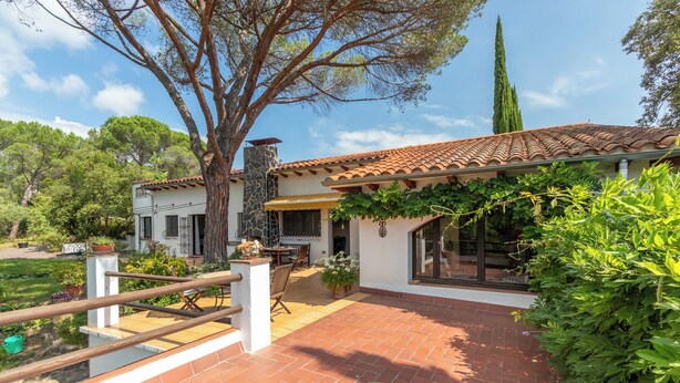 A house with a tiled patio, a stone pillar, and a pergola covered with vines. - Charming Home in a Green Valley. El Pigot. Tranquility, Nature & Private Pool! (Riudarenes)