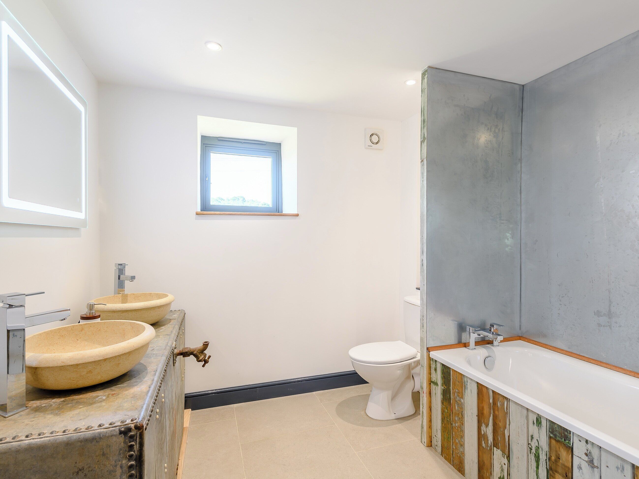 Une salle de bain avec une grande baignoire, deux lavabos et des toilettes.
