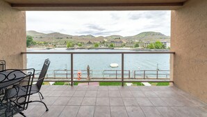 Un balcón con vista a un lago y colinas.