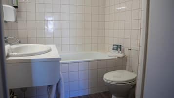 A bathroom with a white sink, a bathtub, and a toilet.