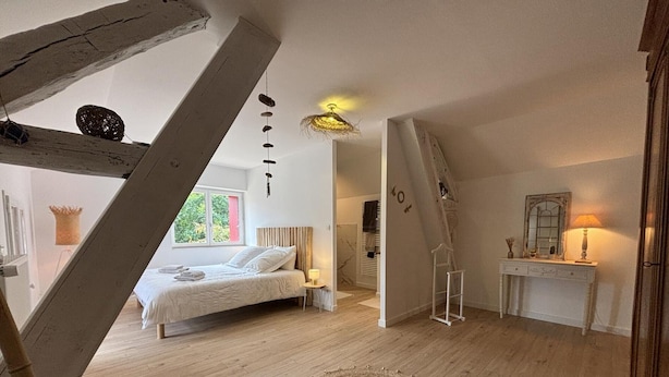 Ein Schlafzimmer mit Bett, Nachttisch, Lampe und einem Teppich.