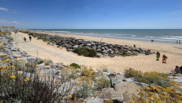 A beach with a rocky path, people walking, and the ocean in the background. - Beachside 2-Room Apartment with Private Garage in Saint-Hilaire-de-Riez (Saint-Hilaire-de-Riez)