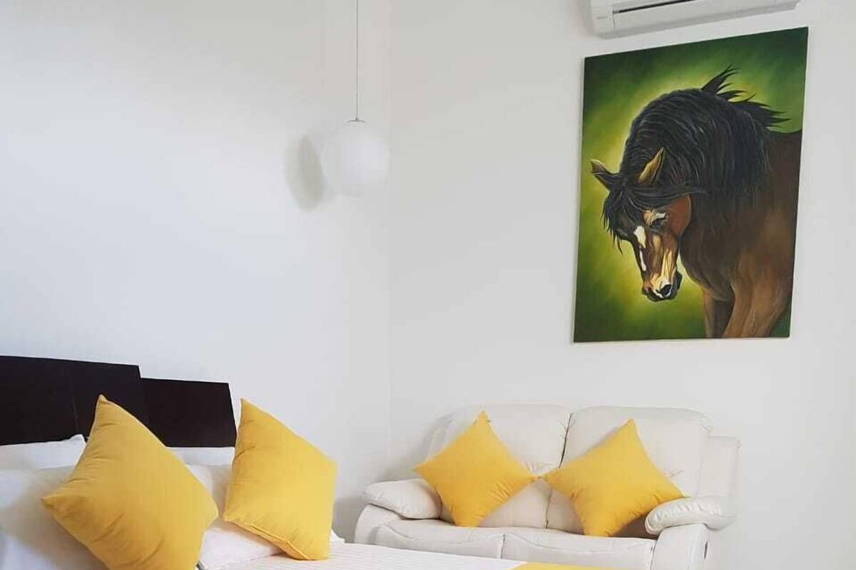 Un dormitorio con cama, sofá y un cuadro en la pared.
