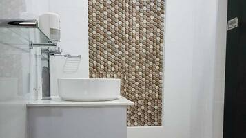 Un baño moderno con un lavabo blanco, un espejo y un inodoro.