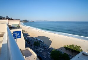 Vista costera desde un edificio alto con vista a una playa, bajo un cielo despejado.