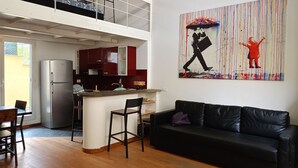 A modern apartment with a kitchen, dining area, and a black leather sofa. - Delightful Loft in Pigneto - to Colosseum in 10 minutes (Roma)