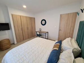 1 dormitorio, caja fuerte, escritorio y tabla de planchar con plancha