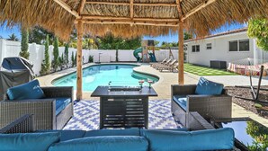 A covered outdoor area with a pool, wicker furniture, and a grill. - Tropical Toucan Retreat w/ Pool (Pompano Beach)