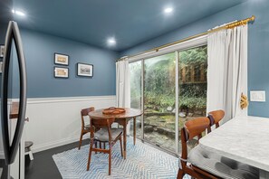 A dining area with a round table, chairs, and a blue patterned rug.