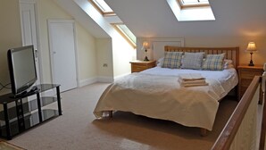 A bedroom with a bed, two bedside tables, a TV on a stand, and skylights. - 4 bedroom accommodation in Hawes (Hawes)