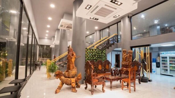 Un vestíbulo espacioso con una escalera, muebles de madera y una máquina expendedora.