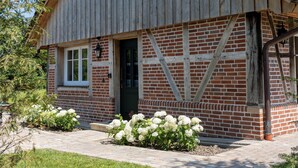 A barn-style building with a red-tiled roof, a wooden exterior, and a brick foundation. - Weitblick- Ruhepol in Münsterländer Parklandschaft (Dülmen)