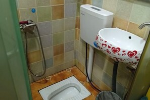 Un baño pequeño con inodoro, lavamanos y ducha.