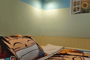 Una habitación con una cama decorada con un personaje de caricatura, una ventana con motivos de girasol y una pared de color claro.
