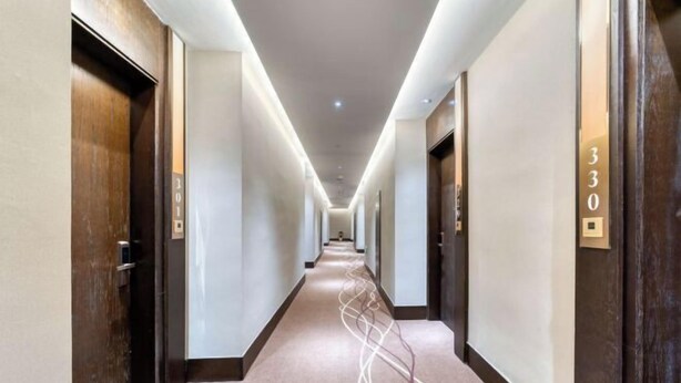 A long, narrow hotel corridor with doors on both sides, numbered 301 and 330, and a carpeted floor. - Ting HOTEL(Ningbo International Convention Center) (Ningbo)