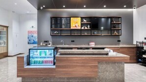 Un espace d’accueil moderne comprenant une vitrine en verre, un comptoir en bois et un tableau de menu fixé au mur.