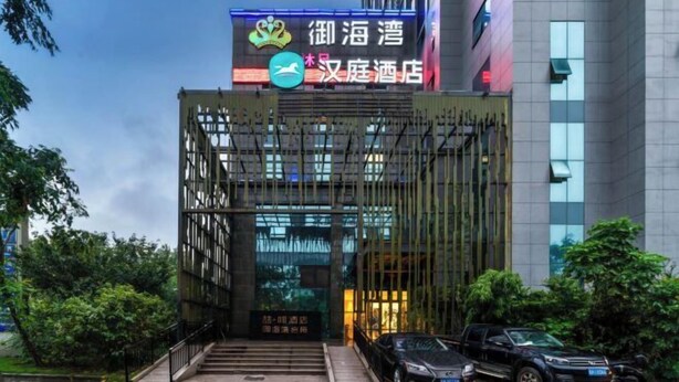 L’entrée d’un hôtel, avec une enseigne indiquant qu’il s’agit d’un hôtel et un nom écrit en caractères chinois.