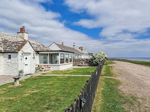 A coastal house with a stone facade, a conservatory, and a view of the sea. - 2 bedroom accommodation in Southerness near Dumfries (Southerness near Dumfries)