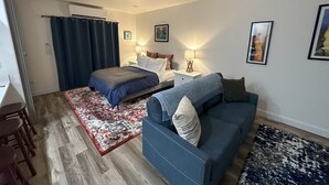 Ein Hotelzimmer mit einem Bett, einem blauen Sofa, einem kleinen Tisch und einem Sessel.