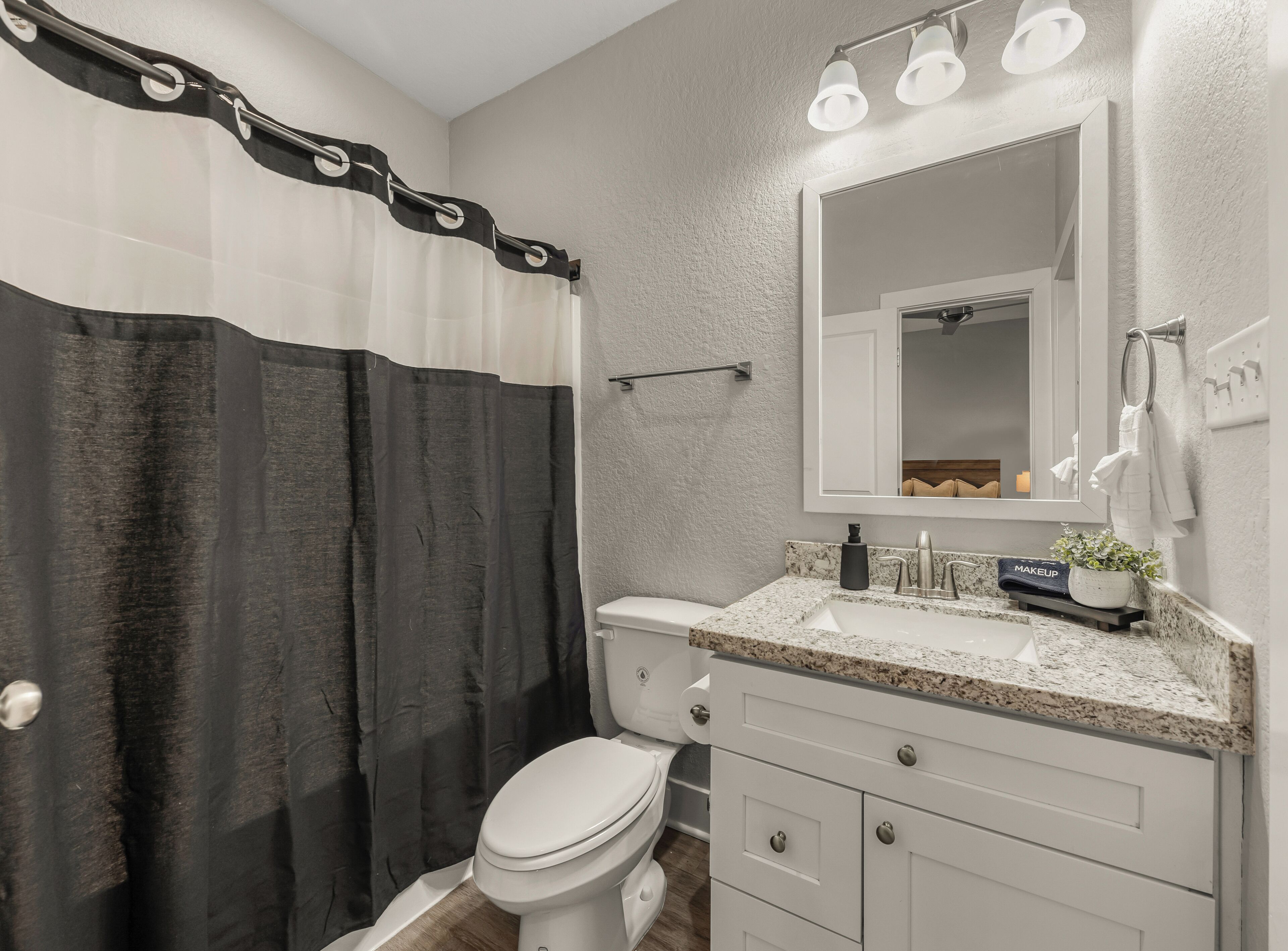 Un baño moderno con cortina de ducha, inodoro, lavabo y tocador.