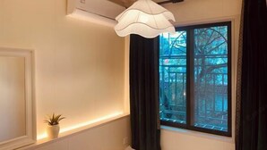 A room with a window, a white wall, a ceiling light, and a small plant. - Xinxin Youth Hostel (Shenzhen Window of the World) (Shenzhen)