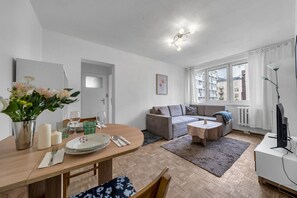 Relax in this inviting space with a dining area, comfortable seating, and a large window offering views of the surrounding buildings.