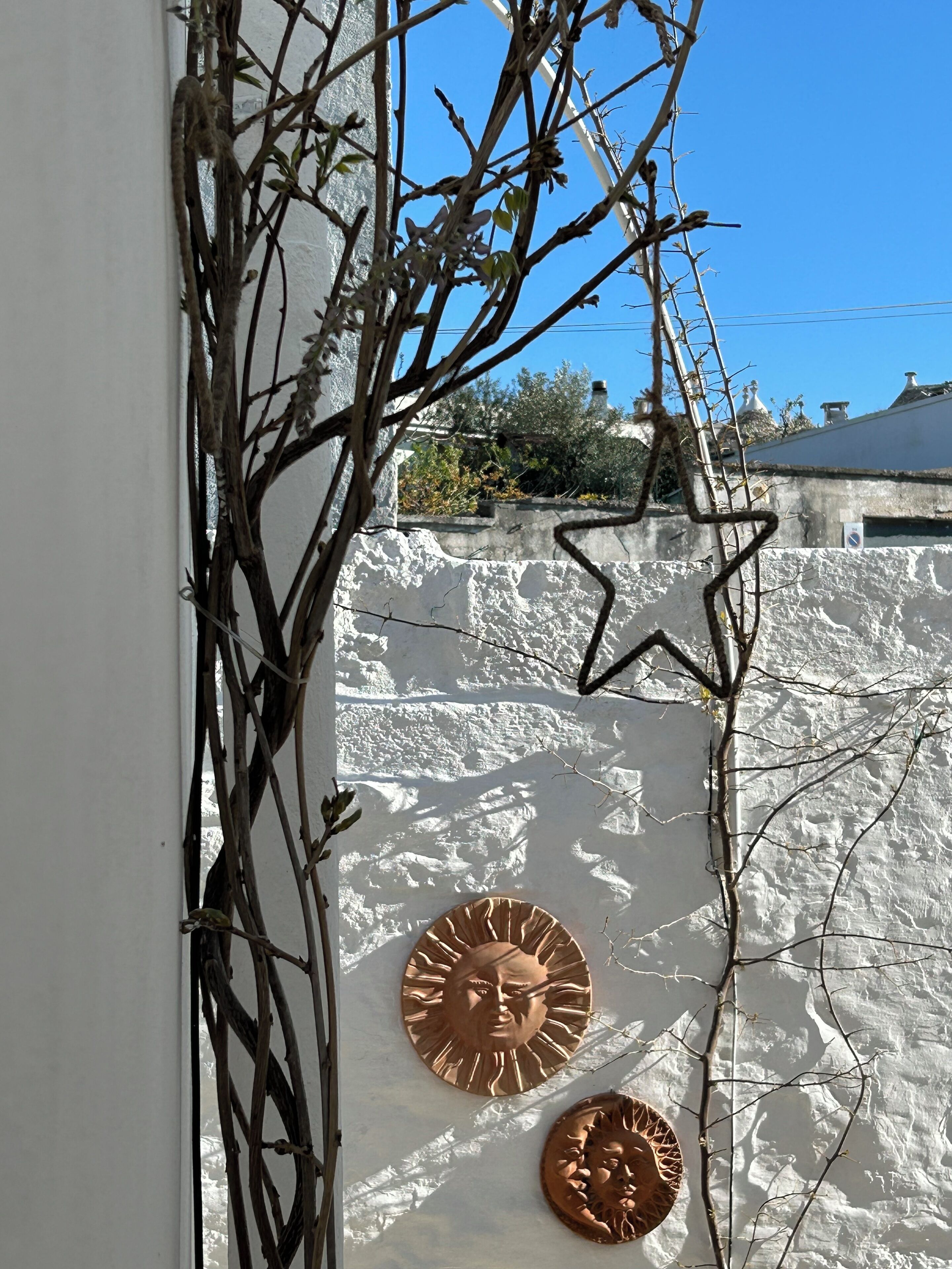 A wall with a textured surface and two circular metal plaques.