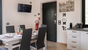 A dining area with a table set for four, a fire extinguisher, a clock, and a coffee machine on the counter. - Panoramic house surrounded by nature just 8 minutes from the beaches of Diamante (Maiera')