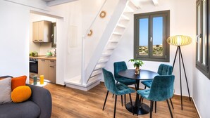 A modern living space with a dining area, a staircase, and a view of the outdoors.