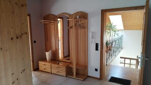 Ein Holzkleiderschrank mit mehreren Fächern, einem Spiegel und einer Kleiderstange.