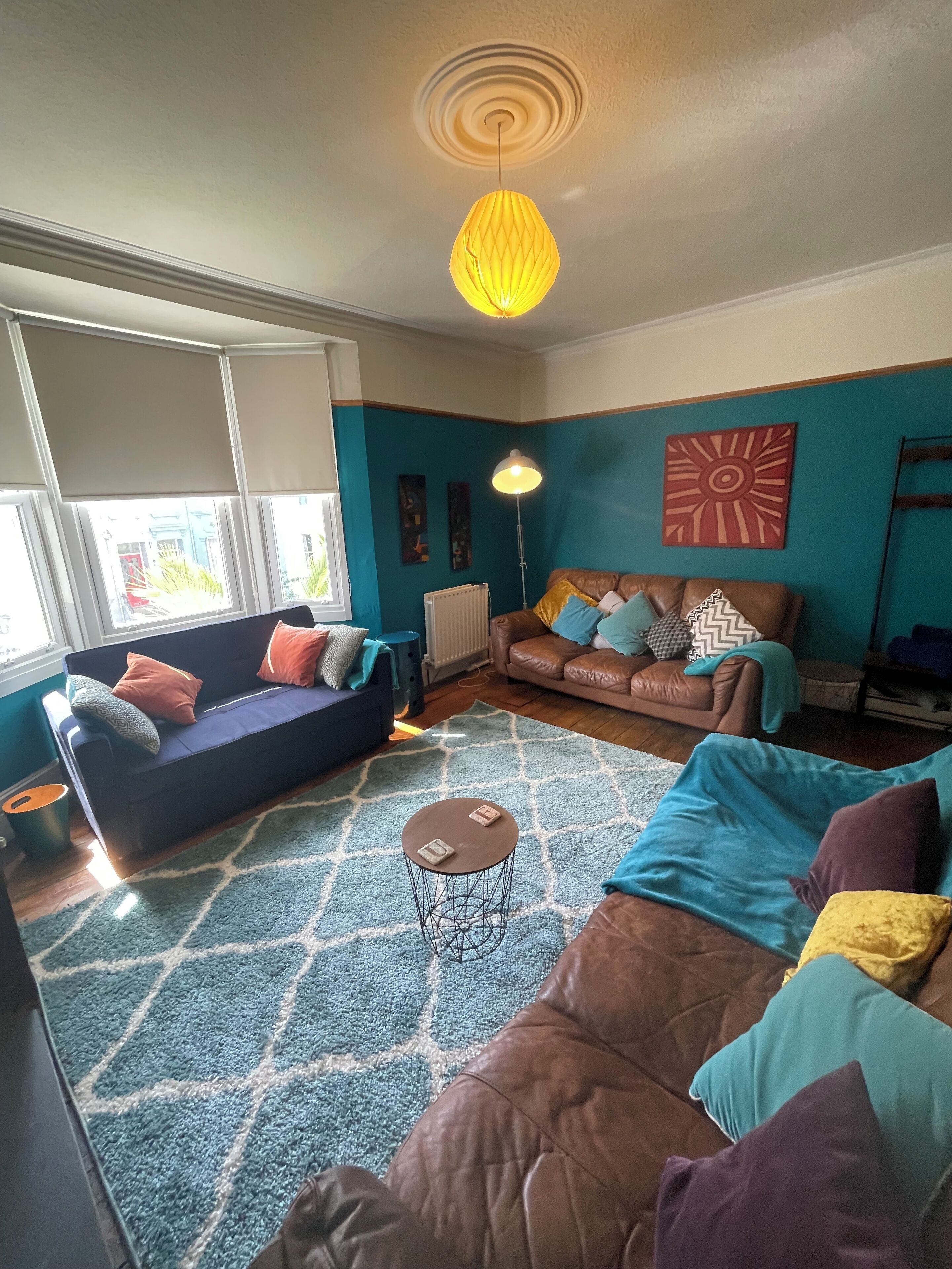 Een woonkamer met twee banken, een bijzettafeltje en een vloerlamp.