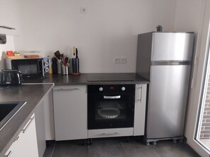 Cozinha compacta com forno embutido, micro-ondas, torradeira e frigorífico.