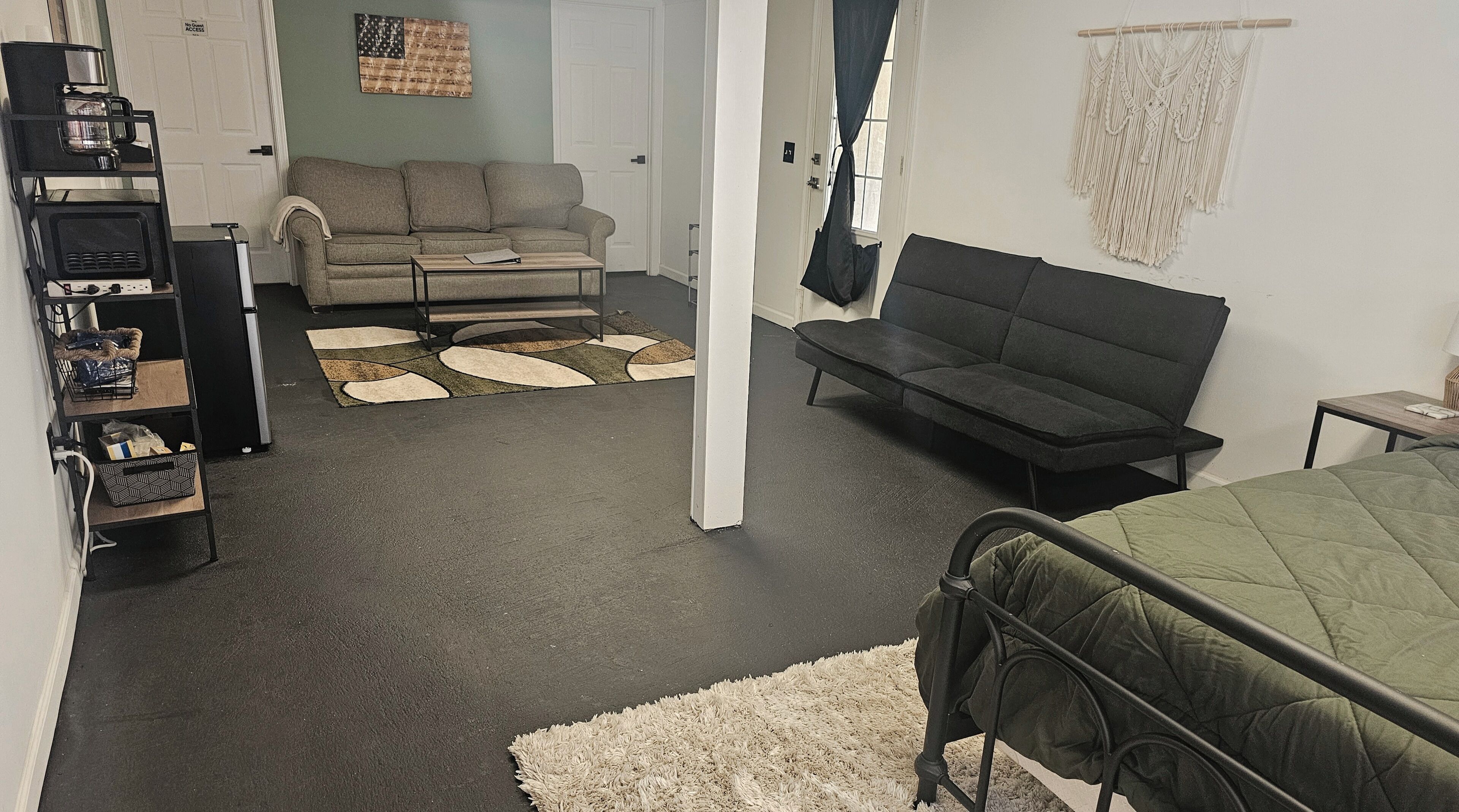 A room with a bed, a sofa, a coffee station, and a couch.