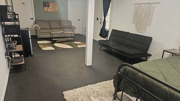A room with a bed, a sofa, a coffee station, and a couch.