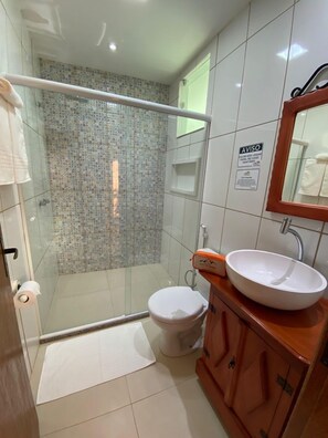 A bathroom with a shower, toilet, and sink.