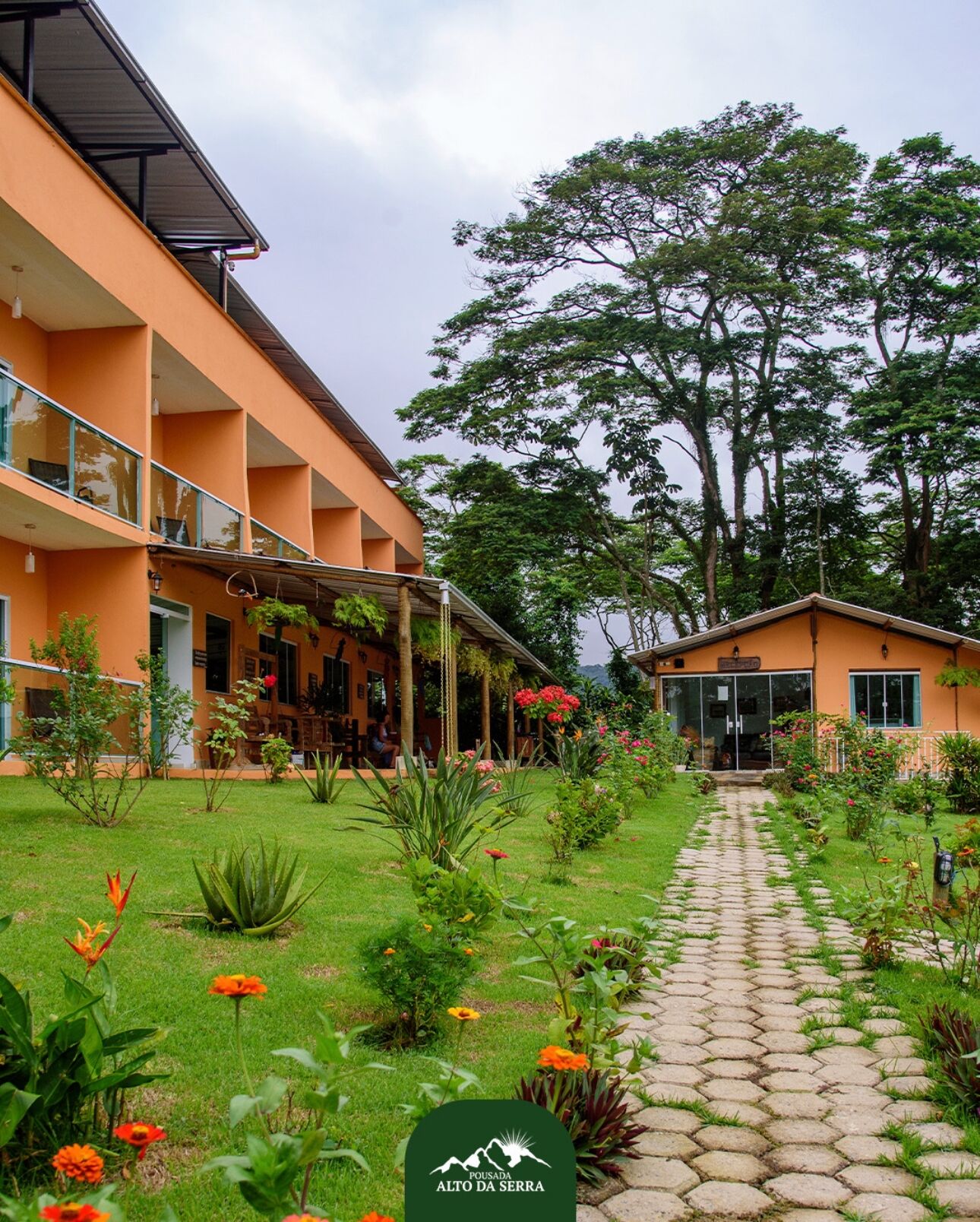 Un hotel con un sendero de jardín que conduce a un edificio con varios balcones.
