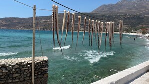 A coastal view with a stone wall and a wooden post. - Detached comfortable stone house with wonderful views 10 min from the sea (Kardamyli)