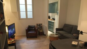 Una sala moderna con un sofá, una silla, una mesa de comedor y un televisor.
