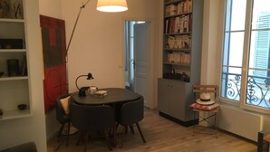 Una sala de estar acogedora con una mesa redonda, una estantería y un ventanal con vistas.