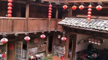 A traditional wooden building with multiple levels, red lanterns hanging, and a tiled roof.