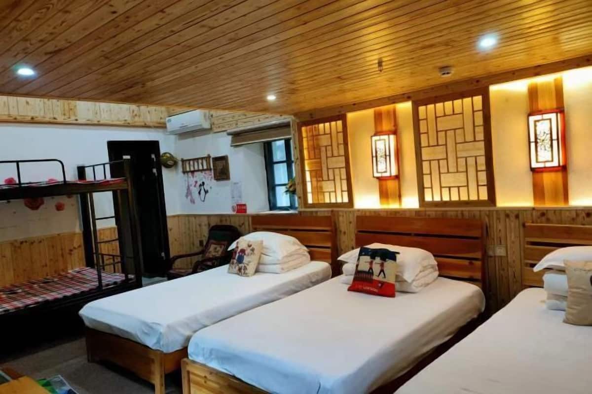 A room with bunk beds, wooden walls, and wall-mounted lights.