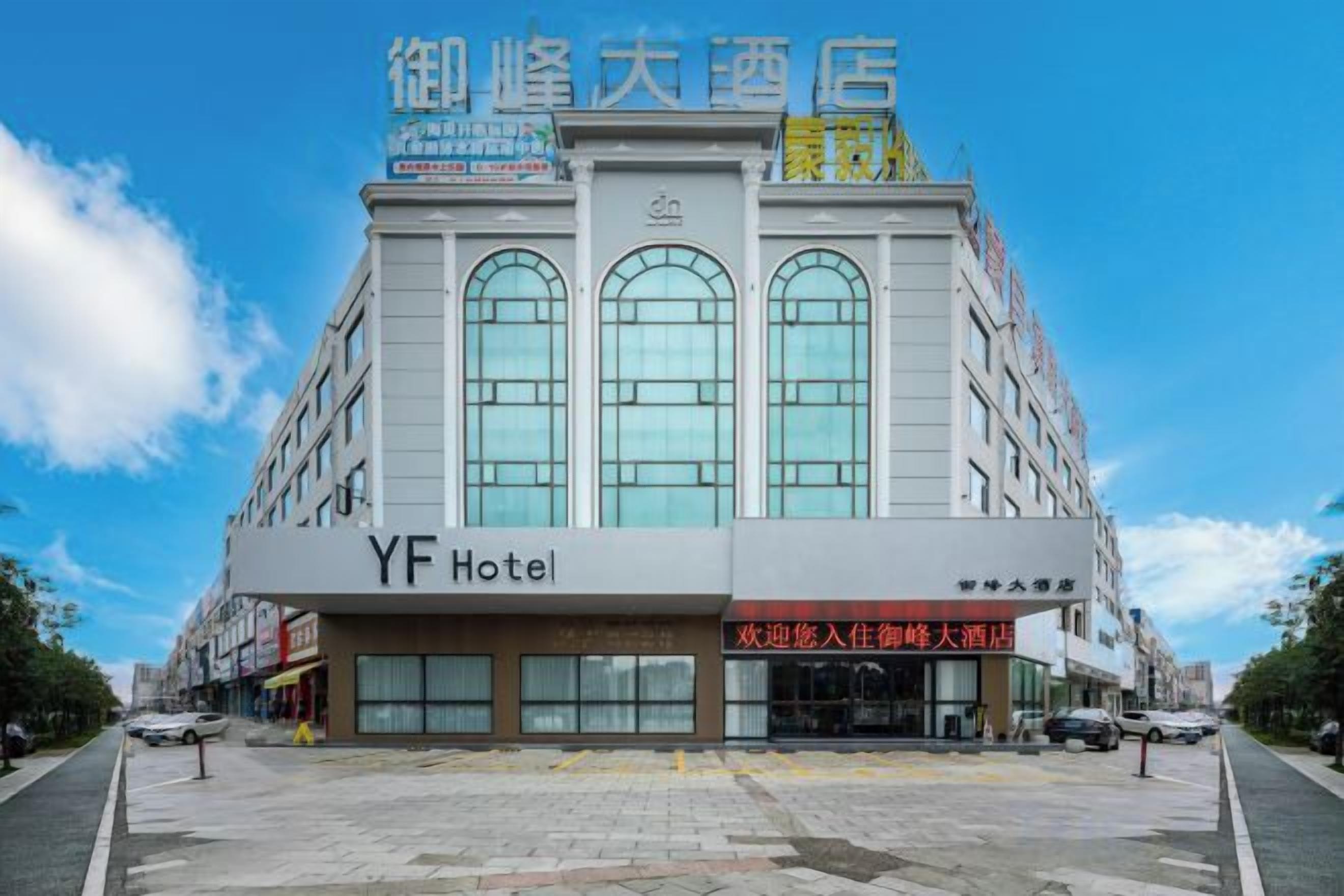 A hotel with a large sign reading 'YF Hotel' and a smaller sign above it.