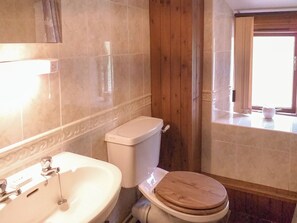 A bathroom with a wooden toilet, a white sink, and a window with curtains. - 2 bedroom accommodation in Hutton, near Weston-Super-Mare (Hutton, near Weston-Super-Mare)