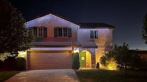 A two-story house with a garage, a front door, and a small porch area.