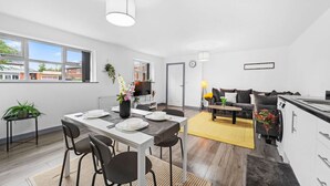 Un appartement moderne comprenant un coin repas, une cuisine et un espace de vie.