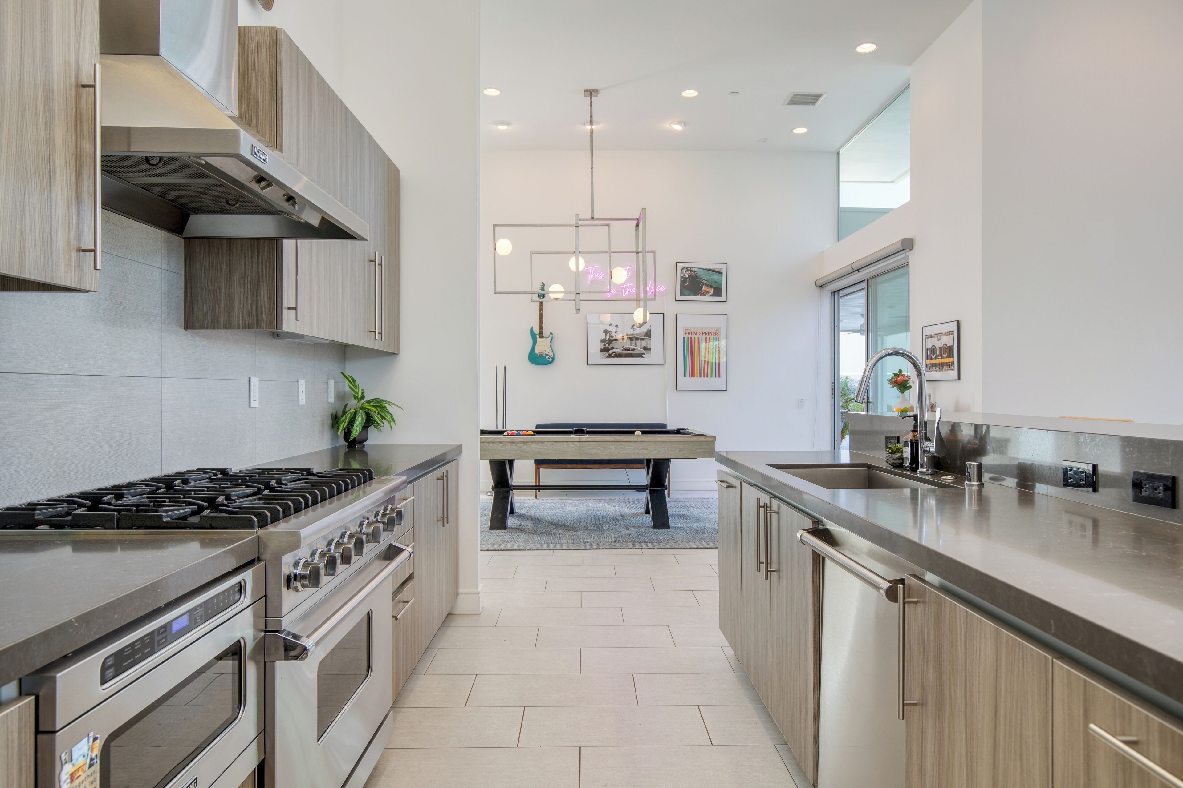 A modern kitchen with stainless steel appliances, wooden cabinets, and a central island.